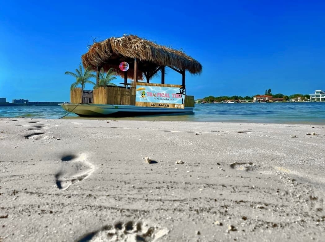 Tiki boat on sandy shore offering coastal bay tour experience