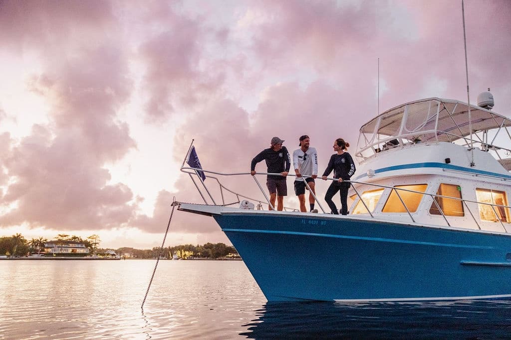 Friends on yacht bow enjoying sunset cruise and ocean views