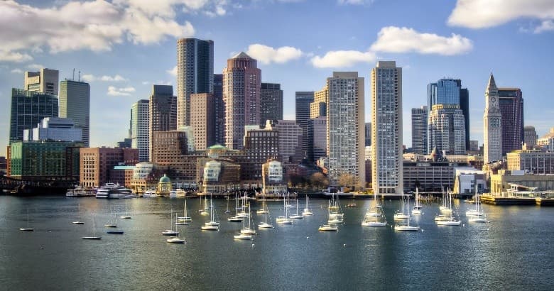 Boston skyline over harbor with sailboats and waterfront views