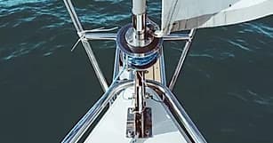 Sailboat bow cutting through deep blue lake waters
