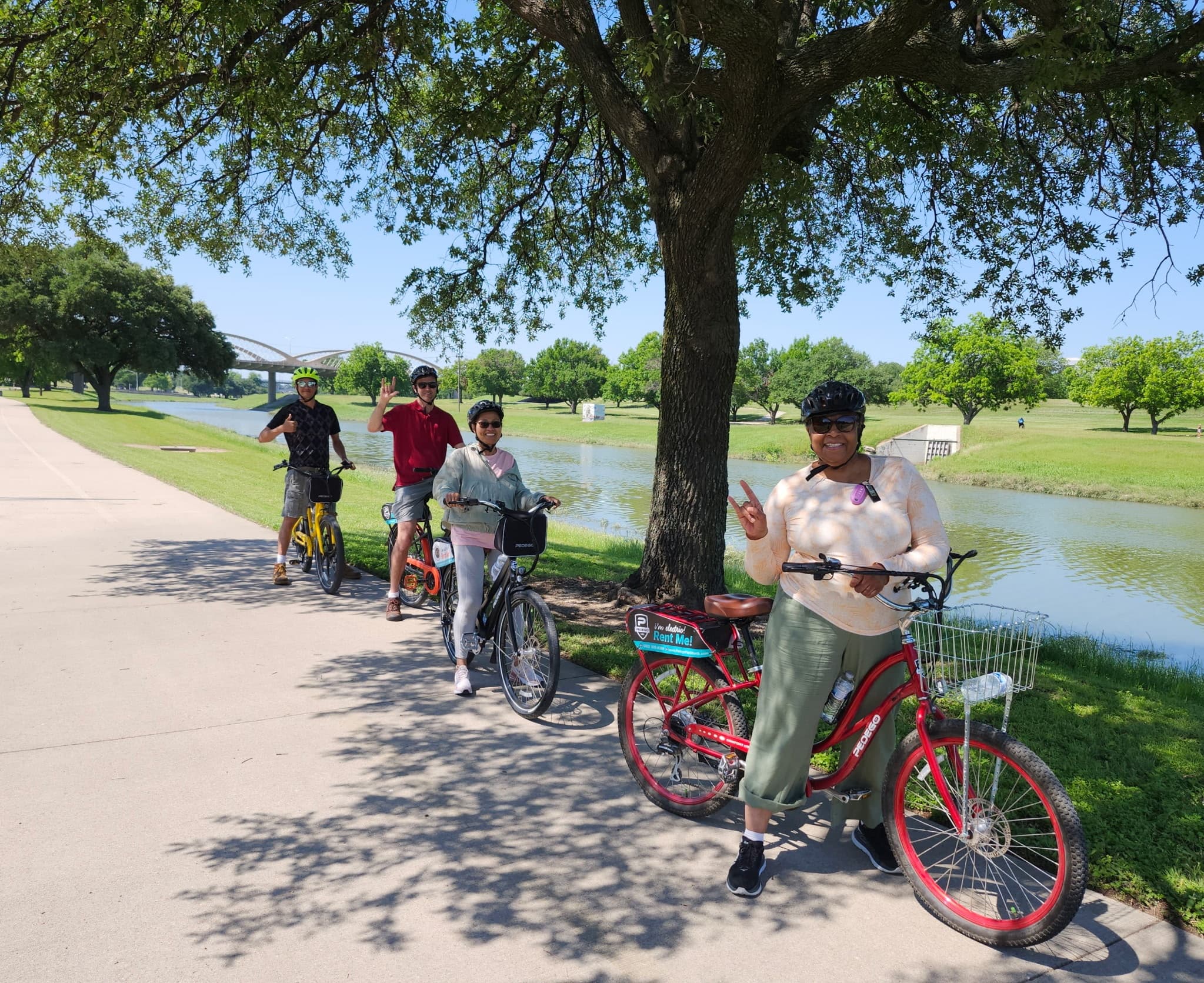 Group e-bike tour paused under shade by Fort Worth lakeside path