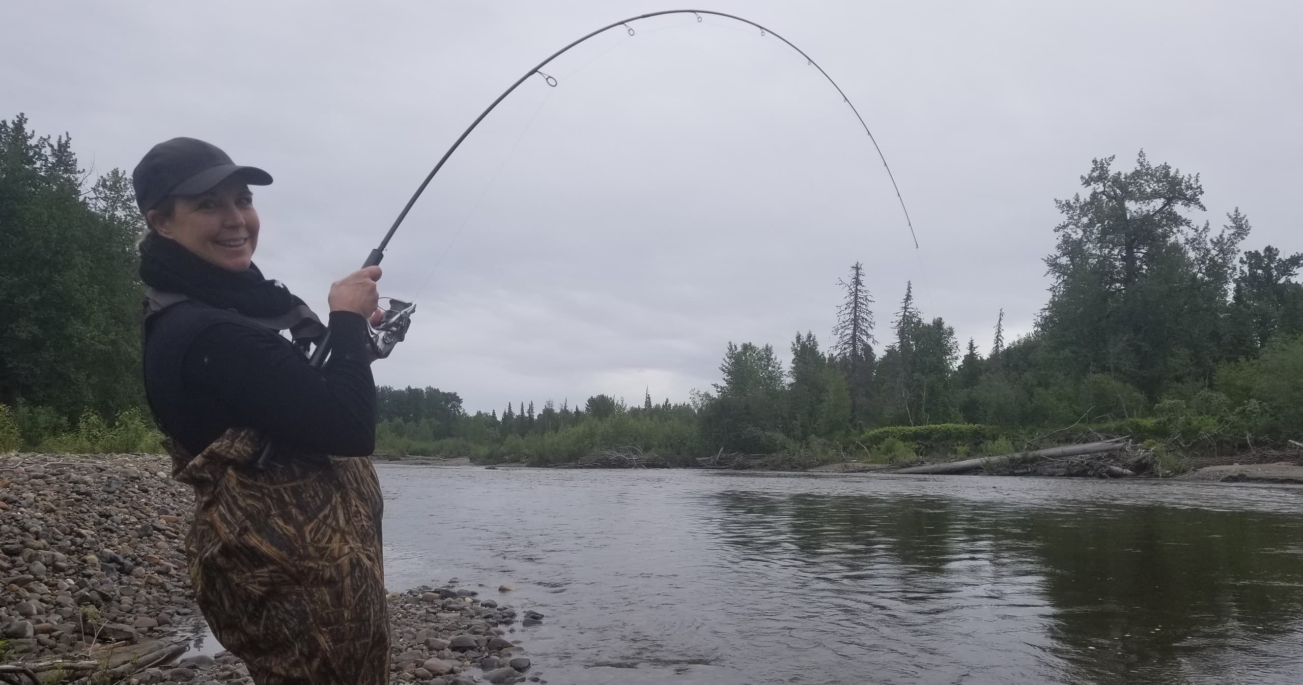 Fisher casting rod on wide Alaskan river during guided trip