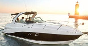 Sunset cruiser near lighthouse on calm lake, scenic boating