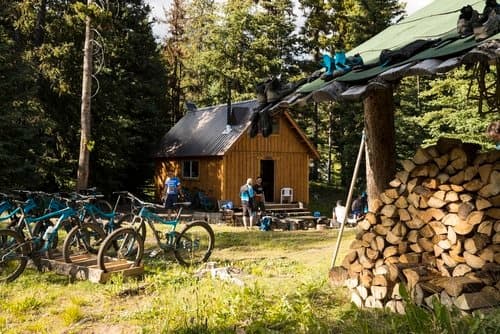 Mountain bikes parked beside rustic cabin at forest campsite
