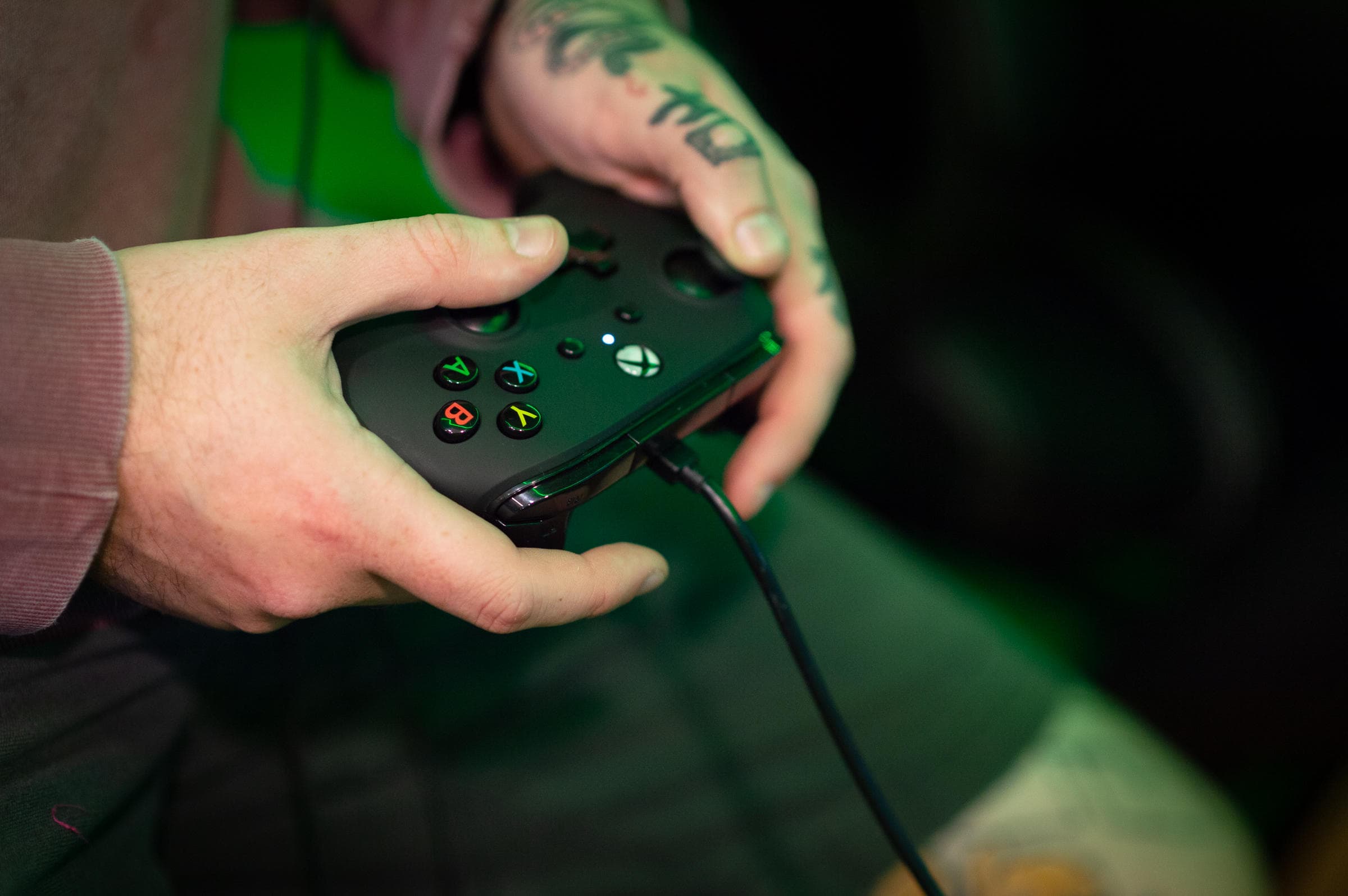 Close-up of handheld gamepad controller in dim esports gaming setup