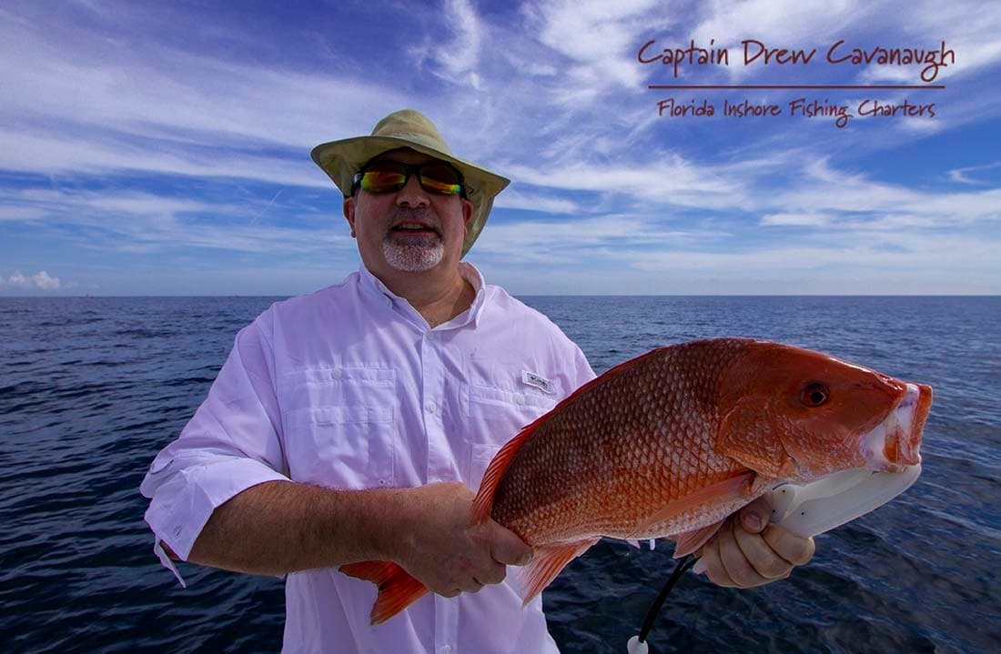 Angler holding red snapper on boat in open Florida inshore waters