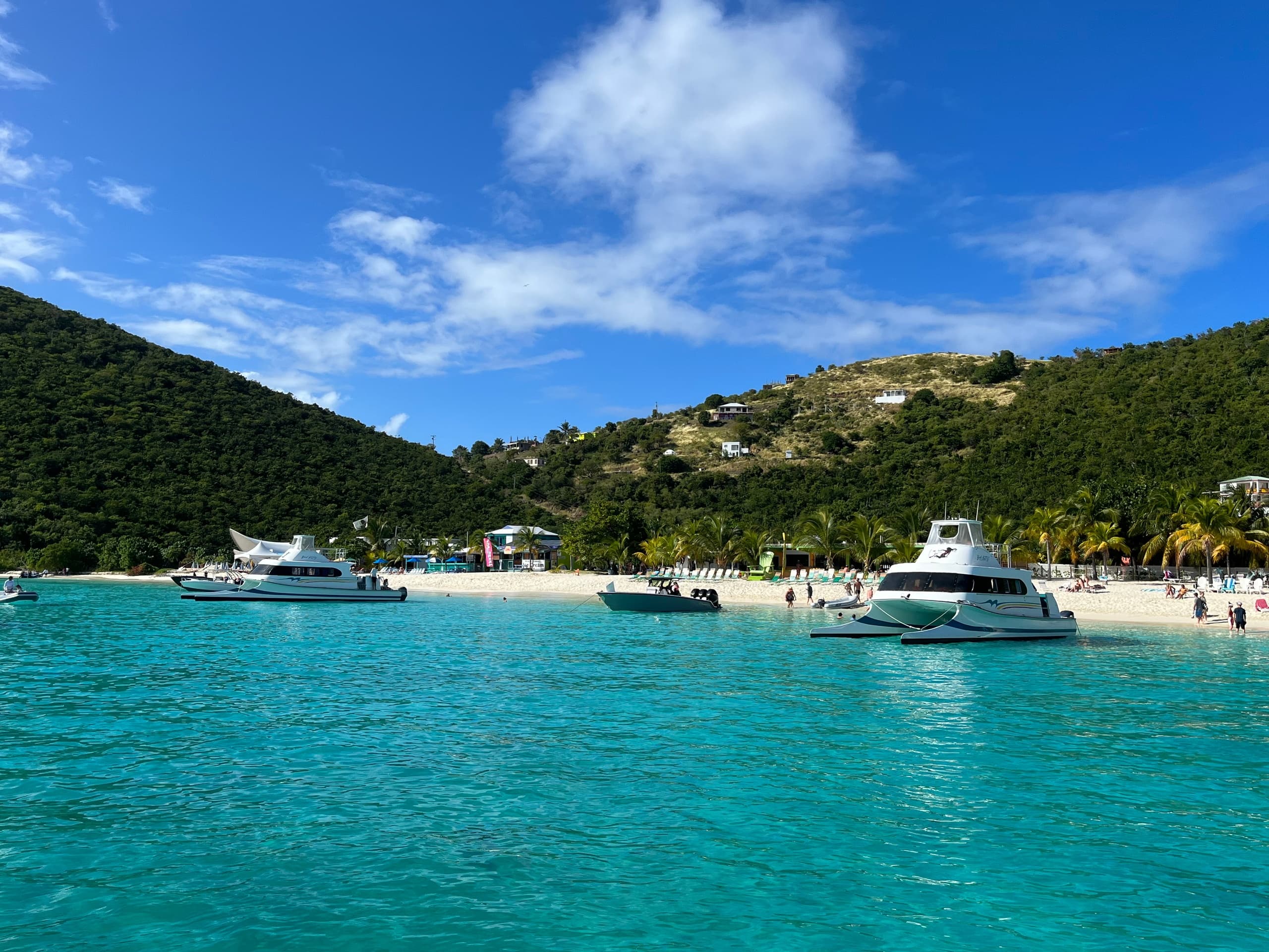 Catamarans anchored in turquoise Caribbean bay near sandy beach
