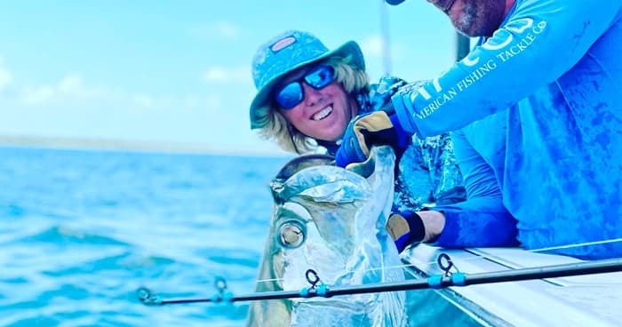 Happy anglers landing a trophy tarpon on offshore fishing trip