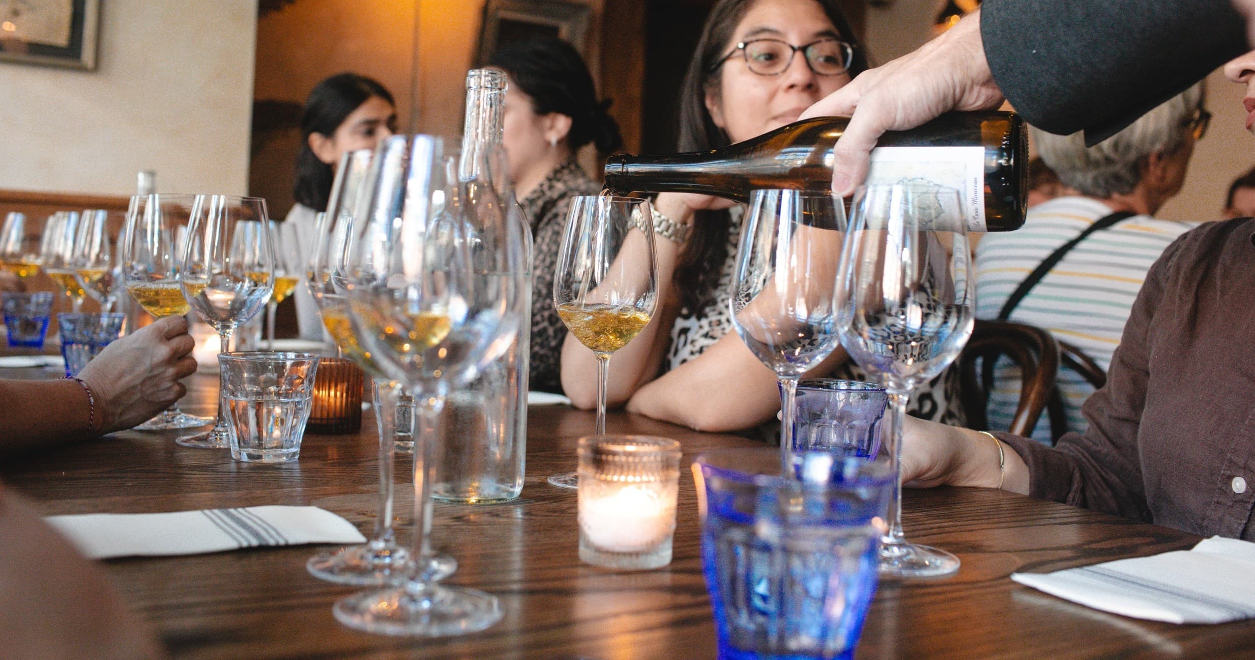 Sommelier pouring wine for group during indoor food tour