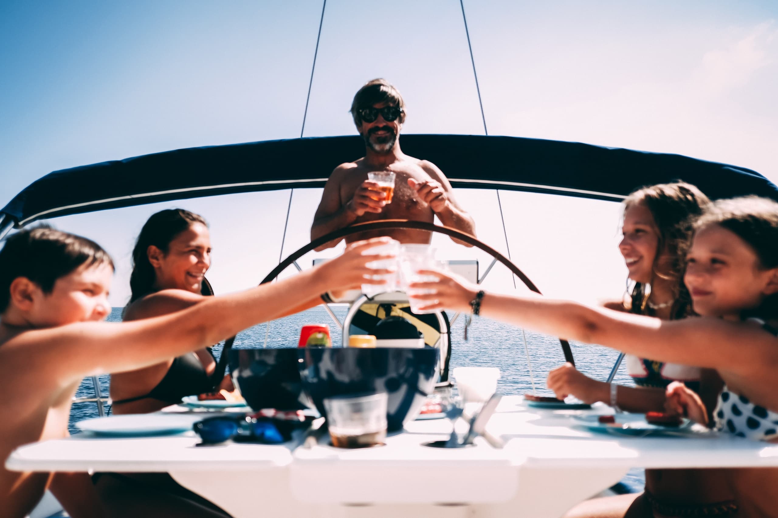 Friends toasting on sailboat deck enjoying sunset cruise