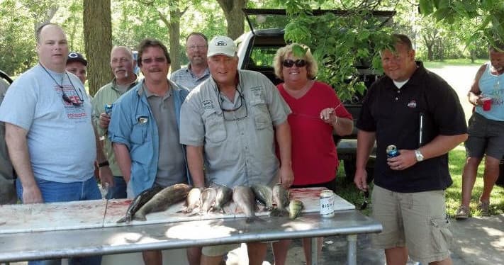 Shoreline walleye fishing outing at park, anglers and catch table