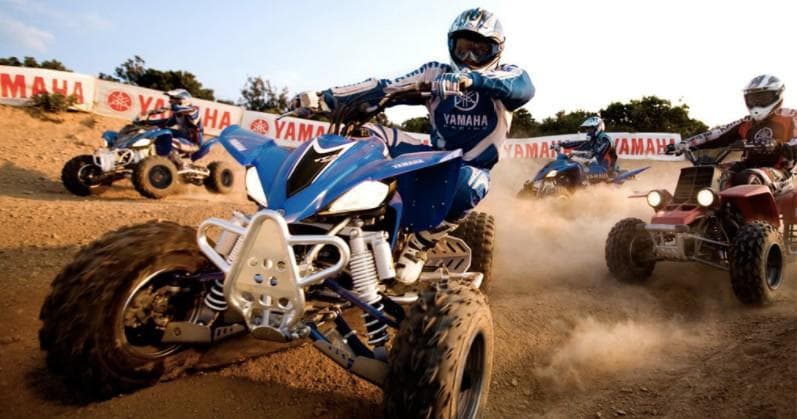 Quad rider racing on dirt track in desert motocross action