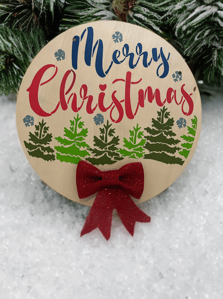 Wooden Merry Christmas ornament on snow-covered outdoor display