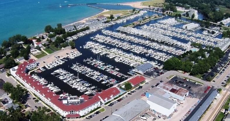 Aerial view of marina and docks on lakeshore, boats moored