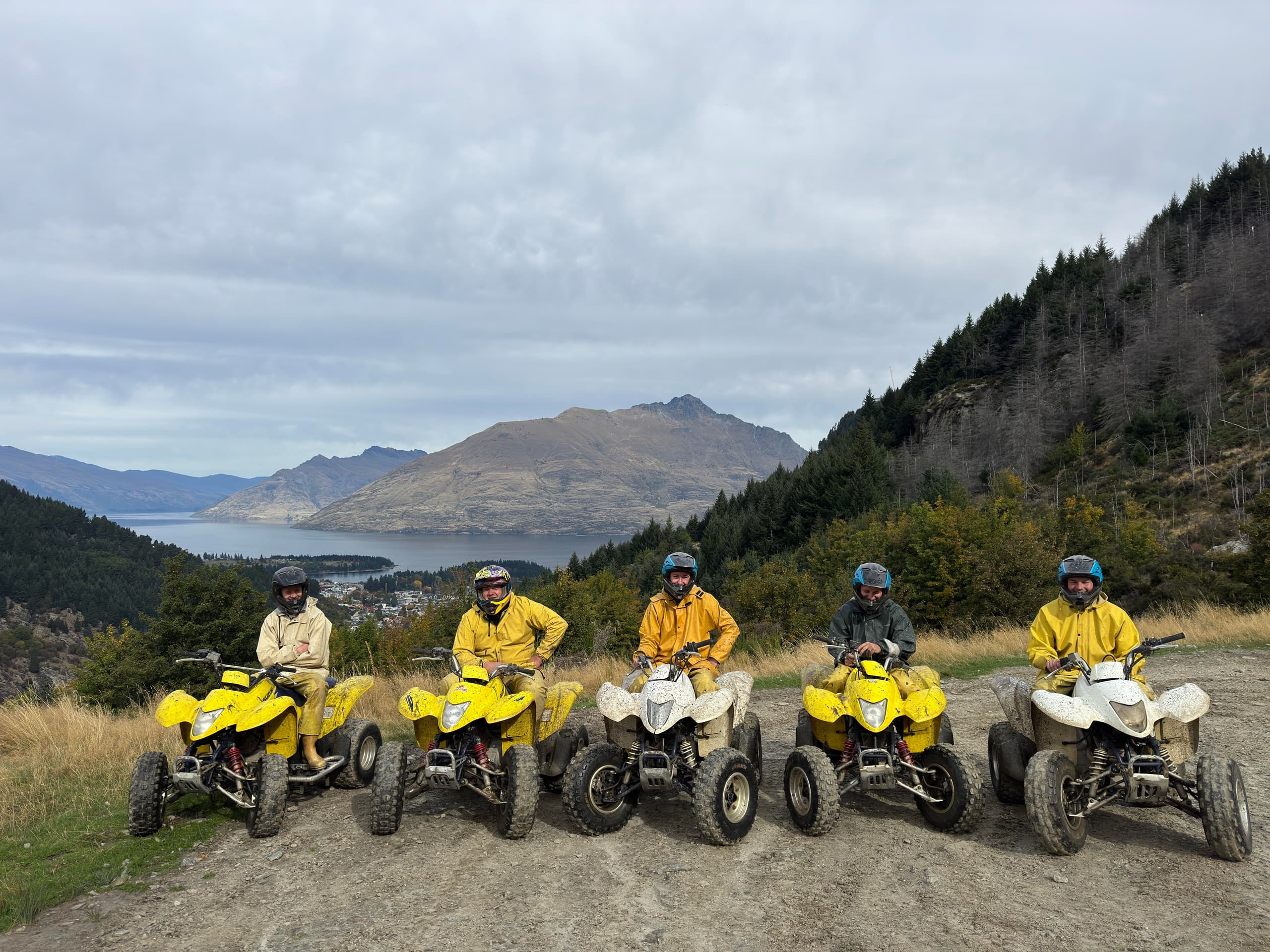 Group ATV tour on yellow quad bikes with lake and hills view
