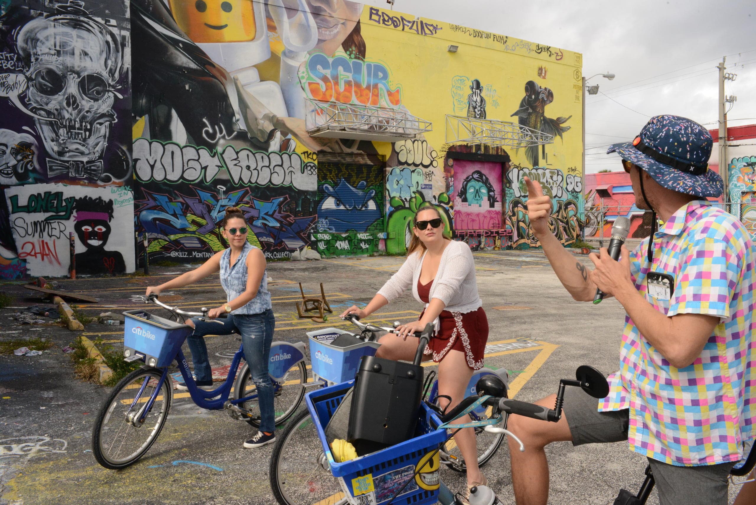 Cyclists posing by colorful Wynwood street mural during tour