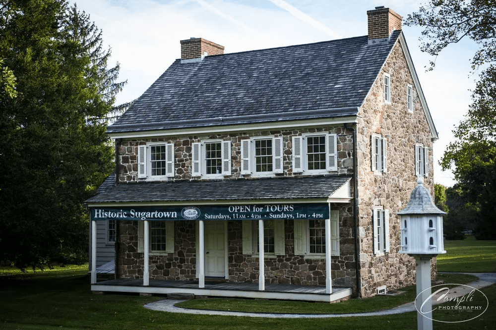 Stone historic house and porch on Sugartown grounds during daytime