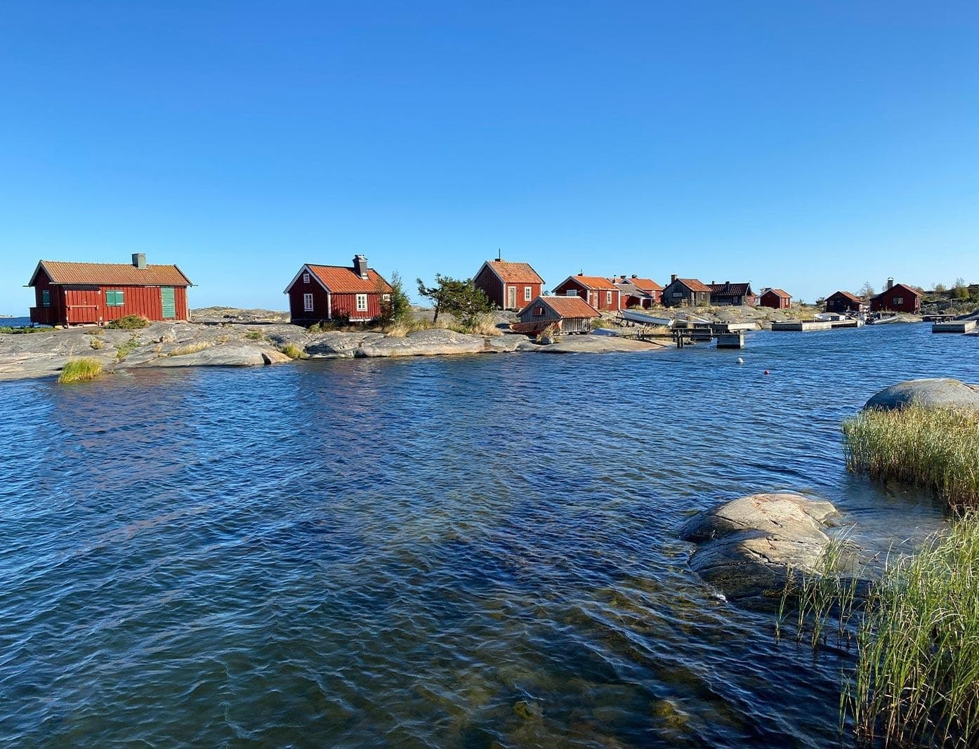 Seaside skerry with red boathouses and calm coastal waters
