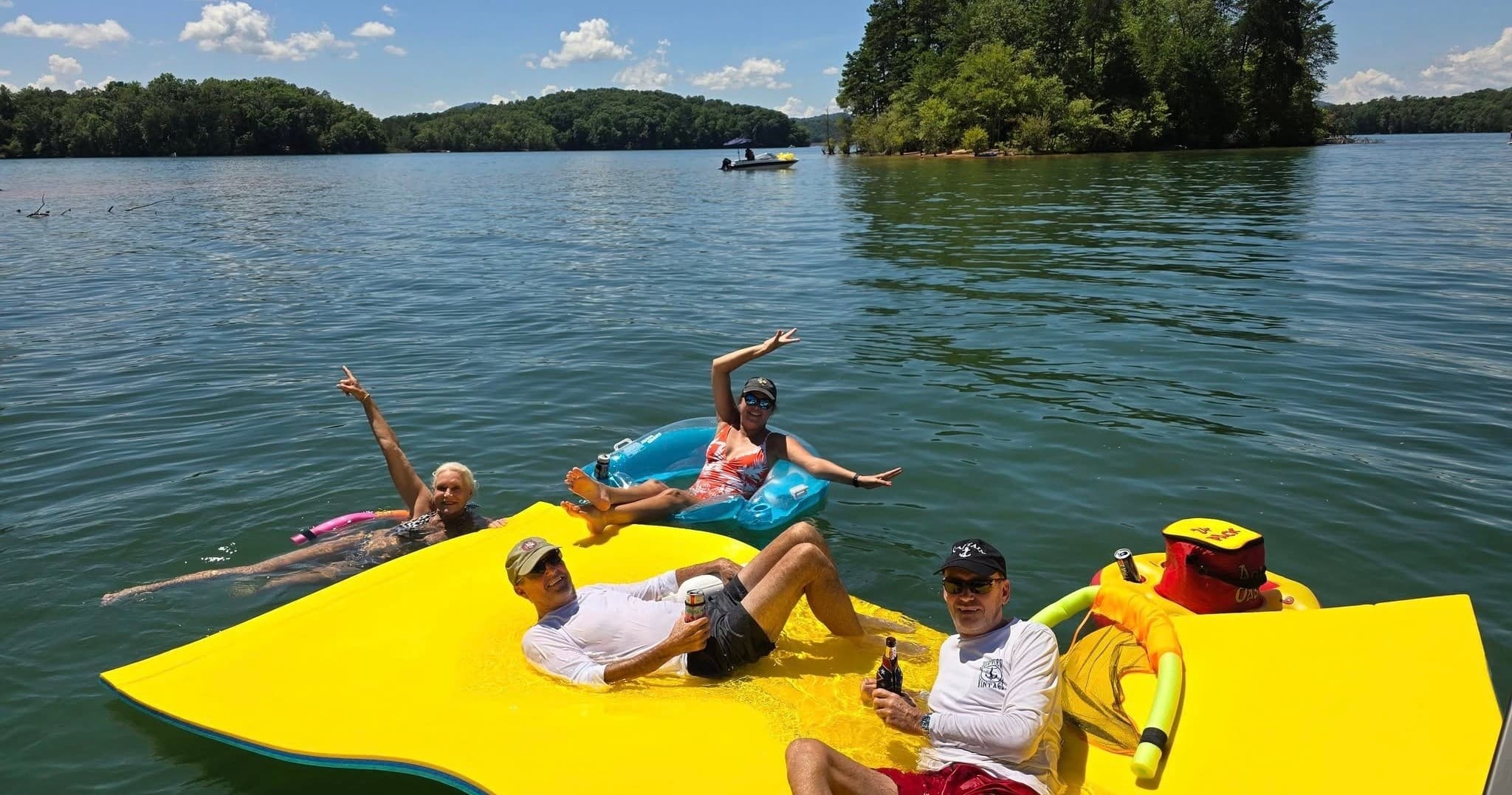 Group lounging on bright yellow floating mat on Lake Chatuge