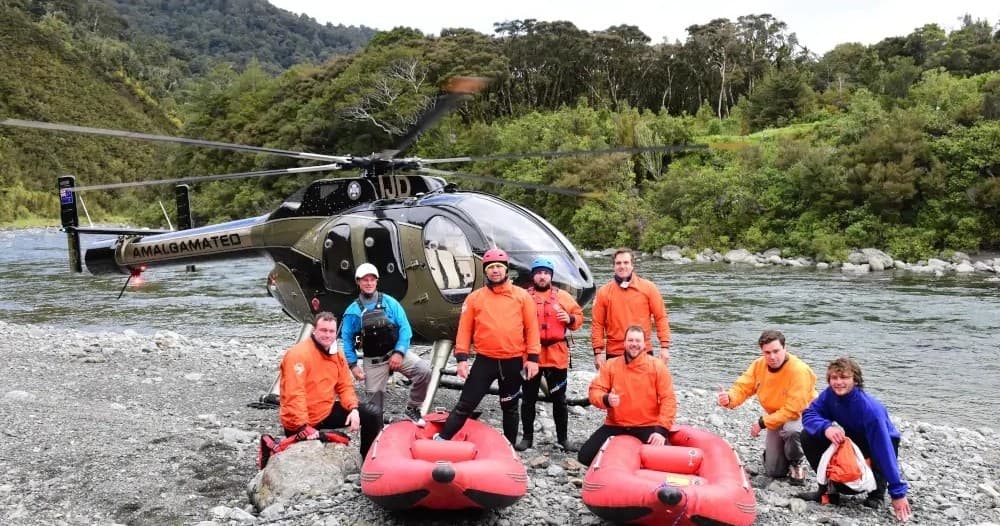 Helicopter drop-off with rafts on riverbank in NZ wilderness