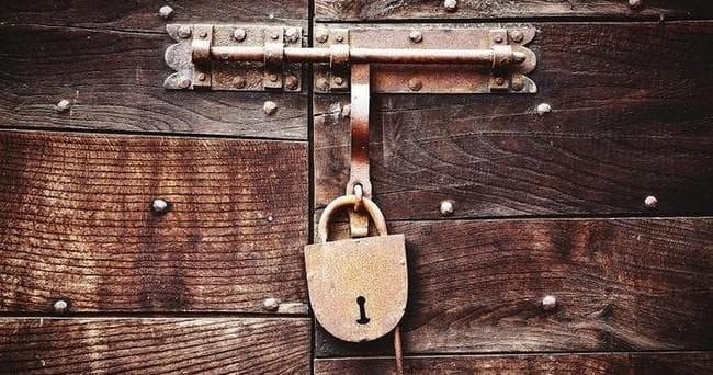 Rustic padlock on wooden door, vintage lock escape motif