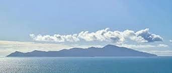 Island skyline over coastal sea with scenic cloudscape