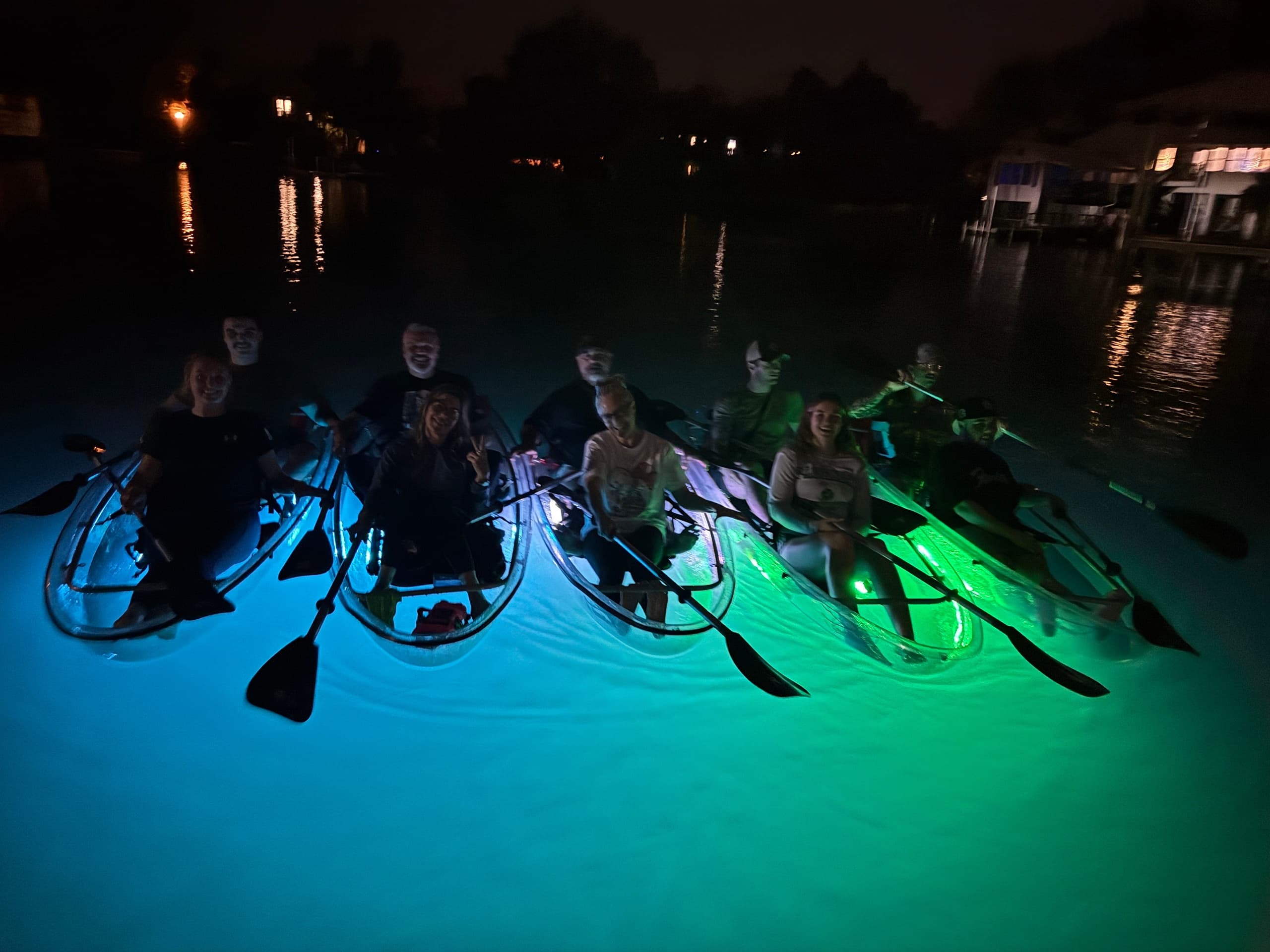 Night kayak tour with illuminated clear-bottom kayaks on bay