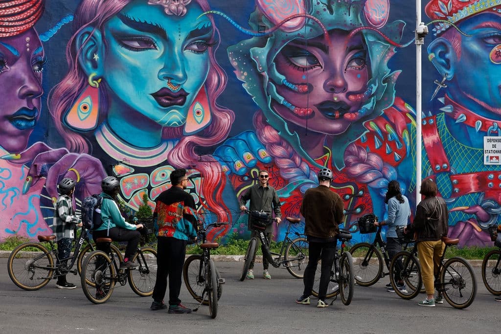 Group bike tour in Montreal stopping at vibrant street mural