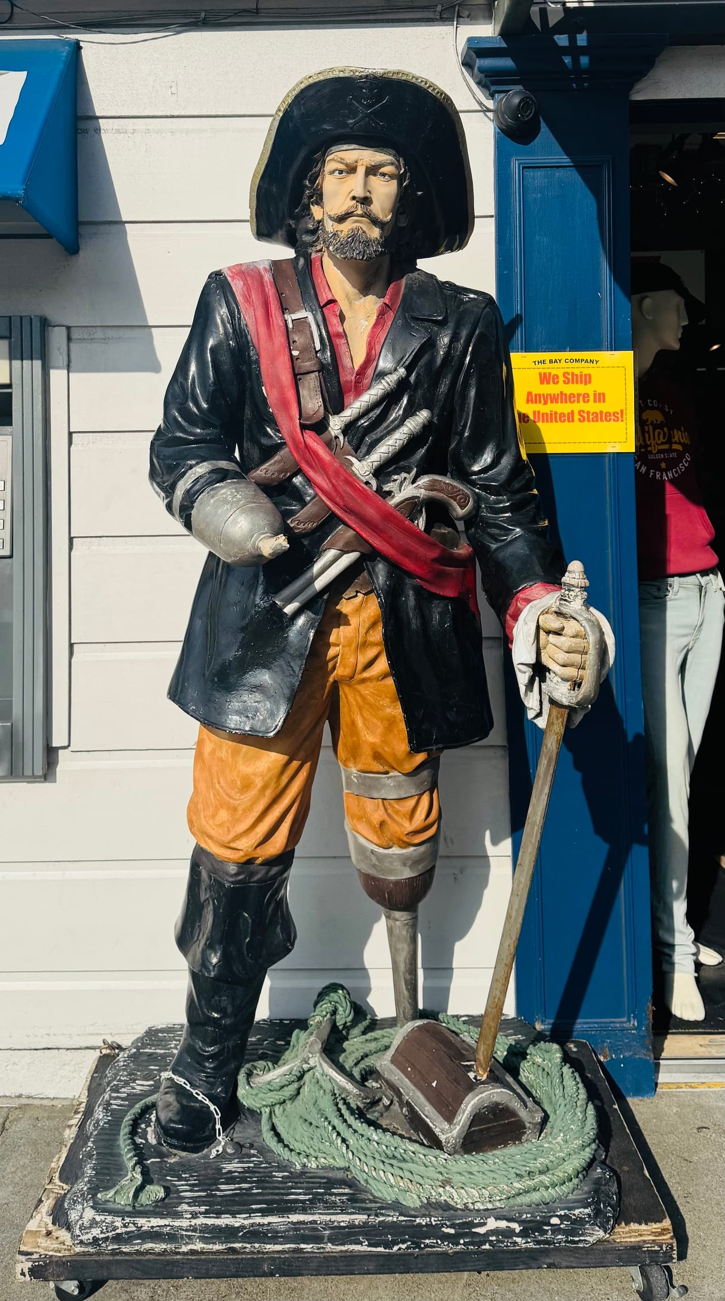 Life-size pirate statue outside souvenir shop on coastal boardwalk