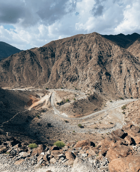 Winding mountain road cutting through arid rocky terrain