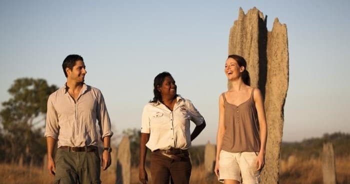 Guided bushwalk past giant termite mound in arid savanna landscape