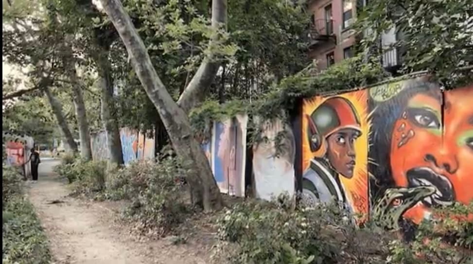 Mural-lined urban walkway showcasing vibrant street art and graffiti