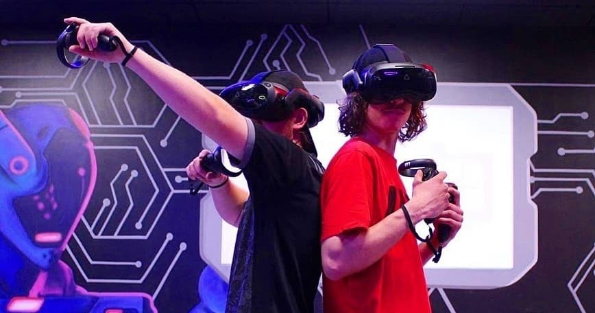 Two competitors wearing VR headsets playing in indoor arena