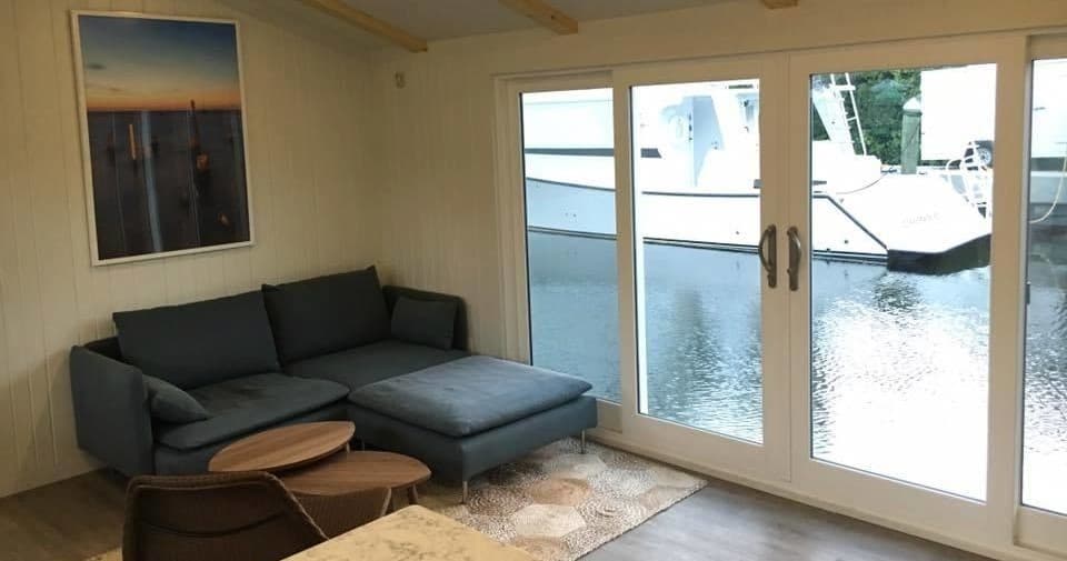 Living room of waterfront houseboat with sliding doors to marina