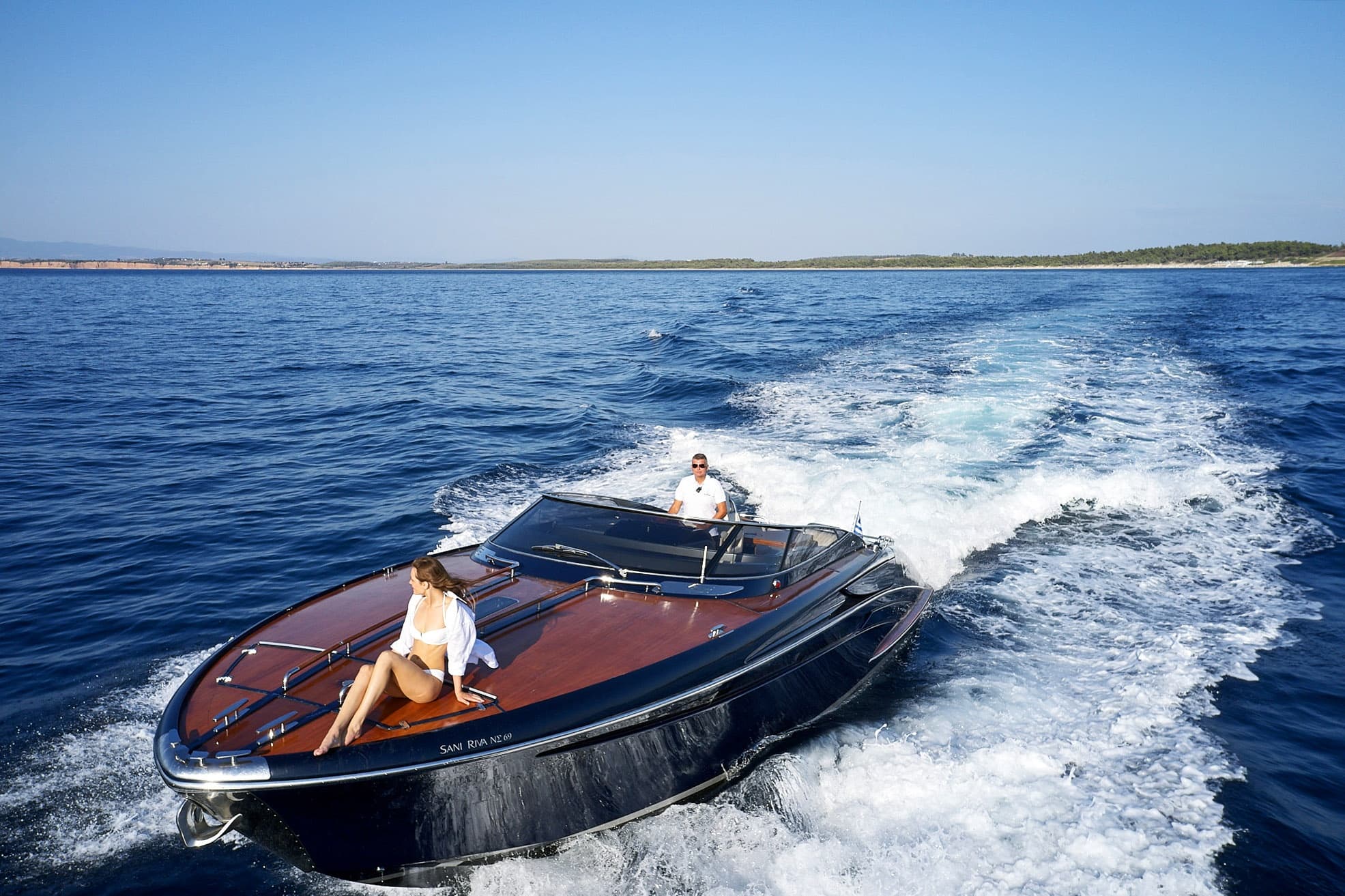 Sleek motorboat anchored in crystal clear lagoon, sunny day