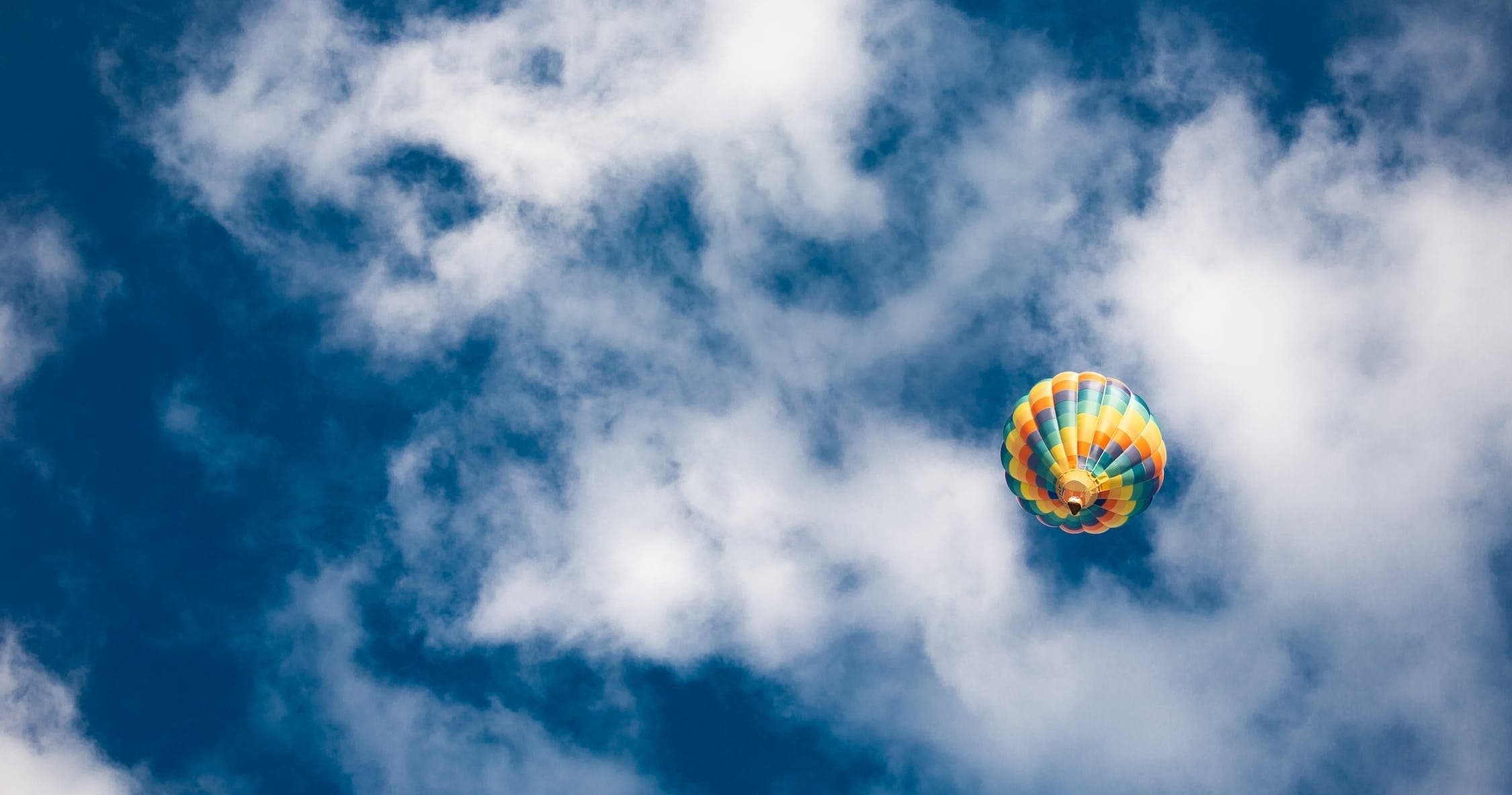 Single hot air balloon drifting through dramatic cloudy sky photo