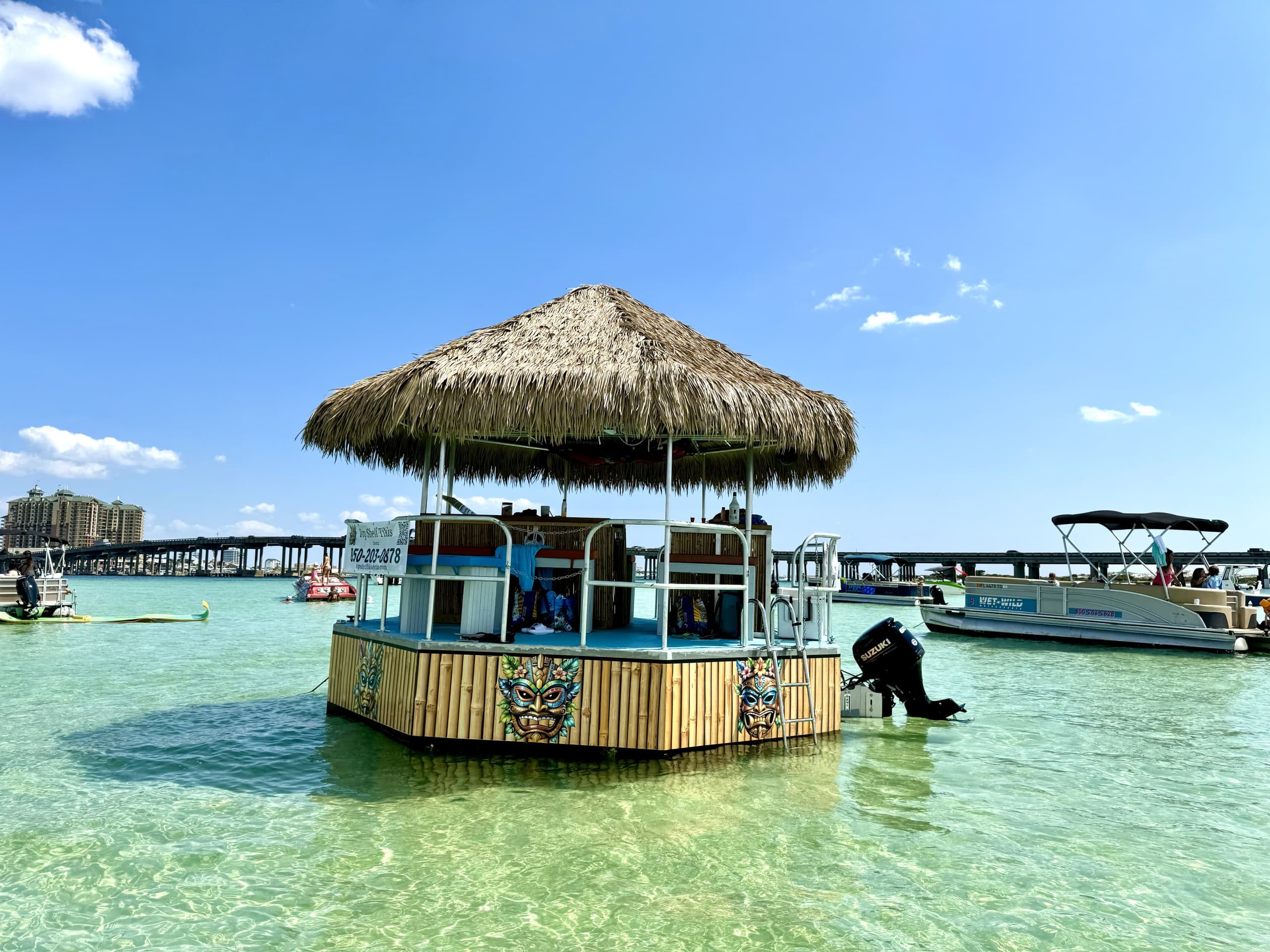 Floating tiki bar moored in shallow clear coastal lagoon