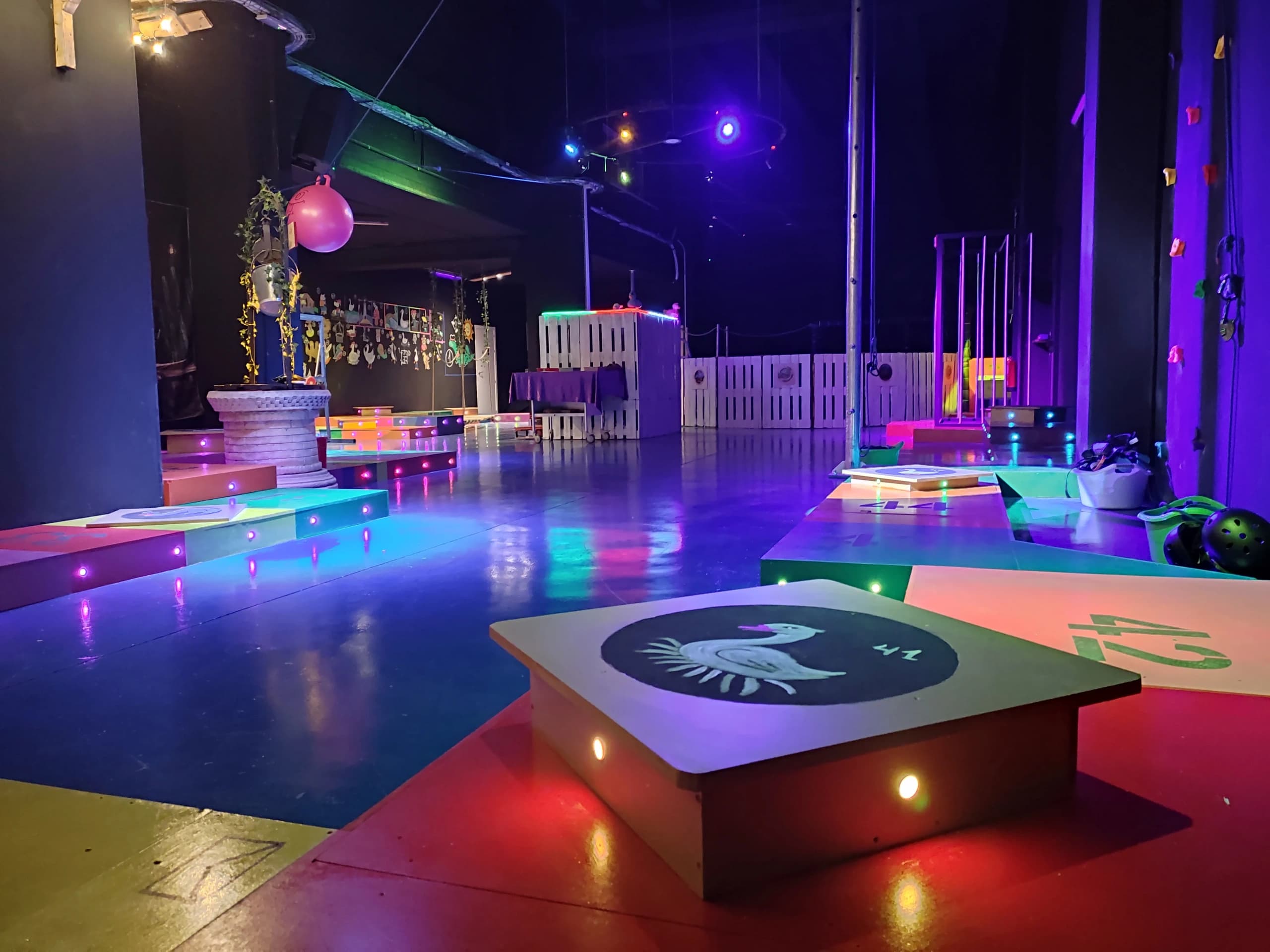 Indoor glow mini golf course with neon lights and obstacles