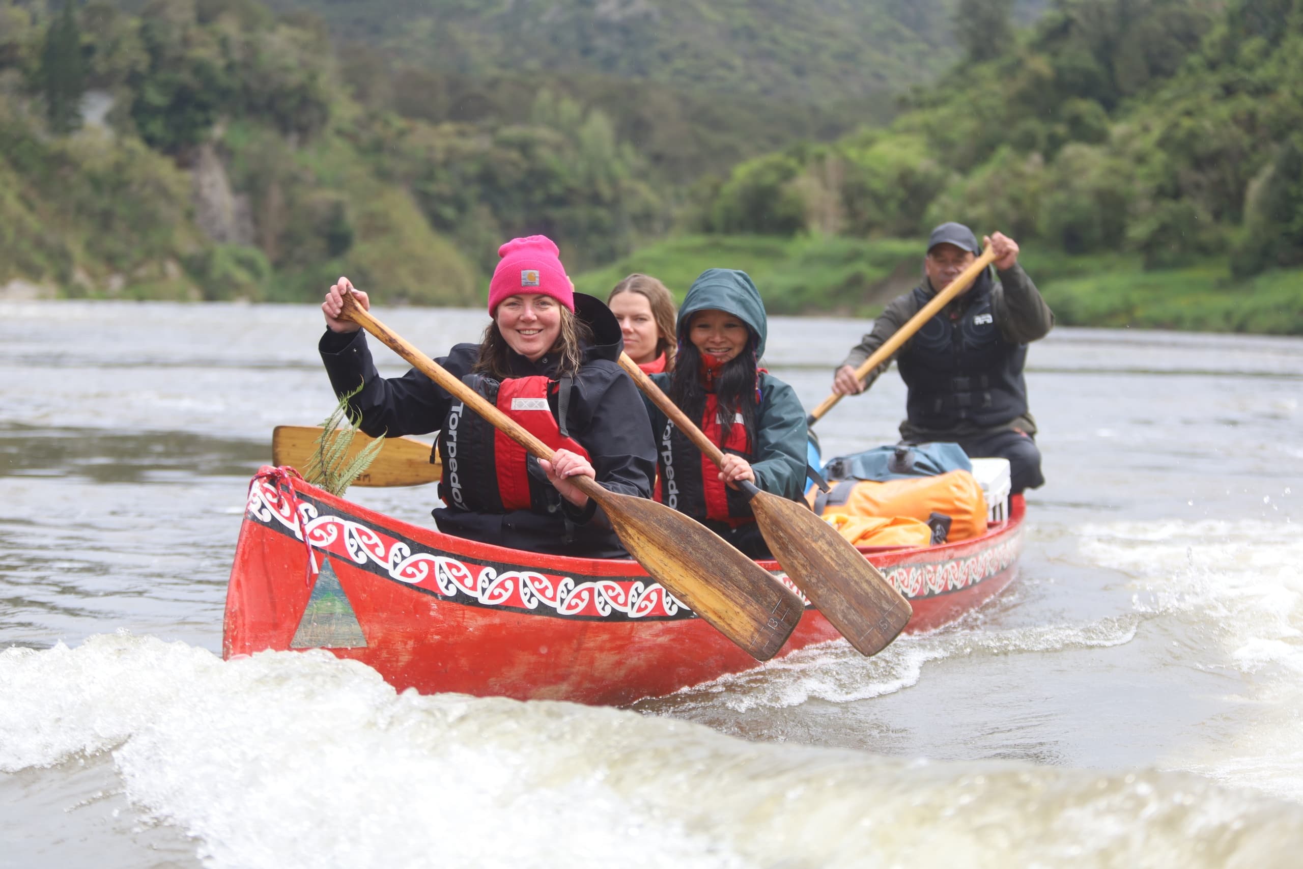 Whitewater canoe team paddling rapids on scenic river trip