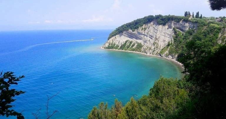 Turquoise coastal bay with cliff views, seaside hiking destination