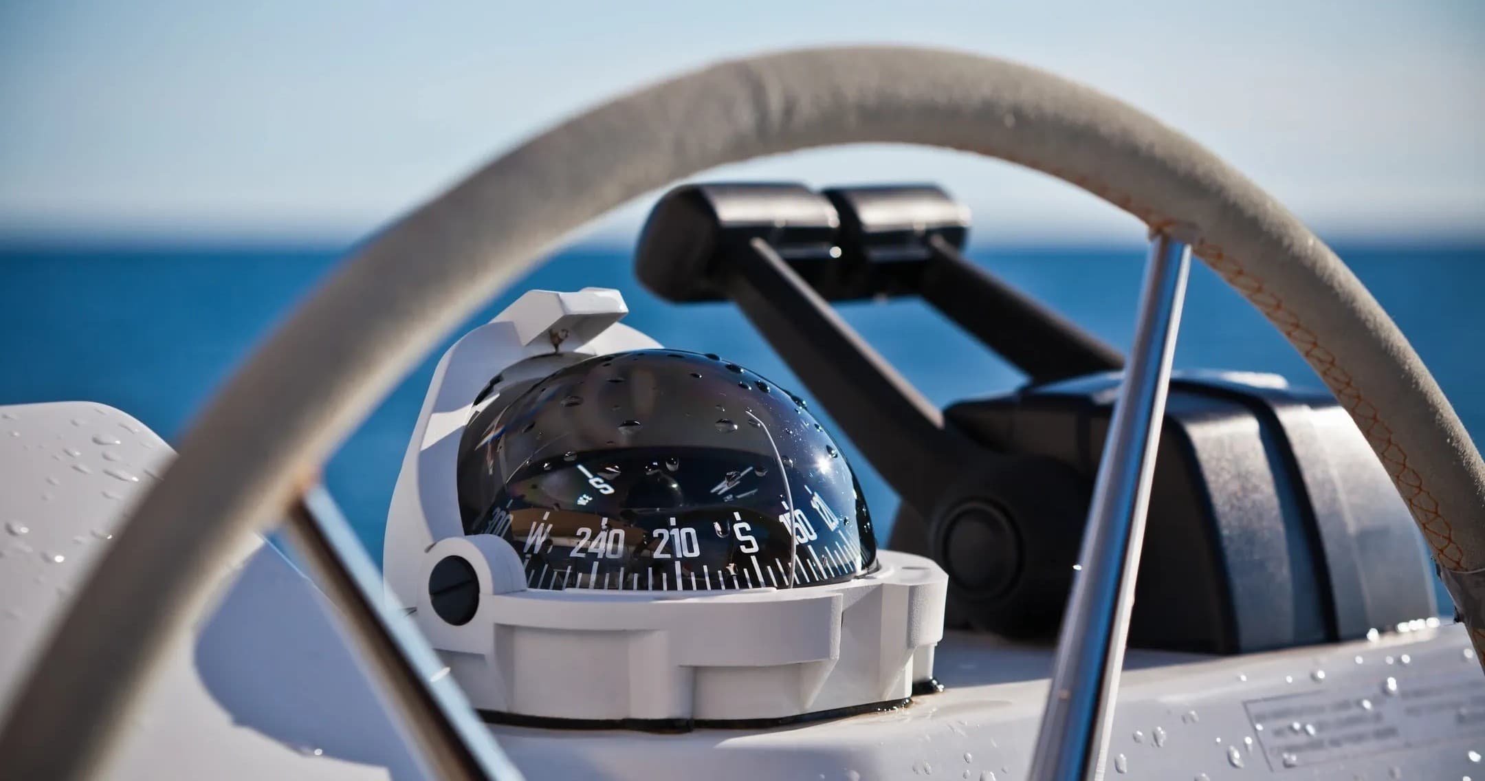Sailboat helm with compass navigating Lake Michigan near Chicago