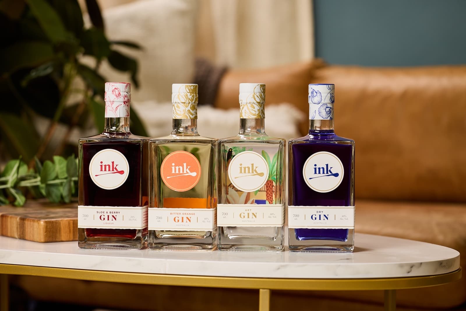 Ink gin bottles styled on marble table in cozy tasting room