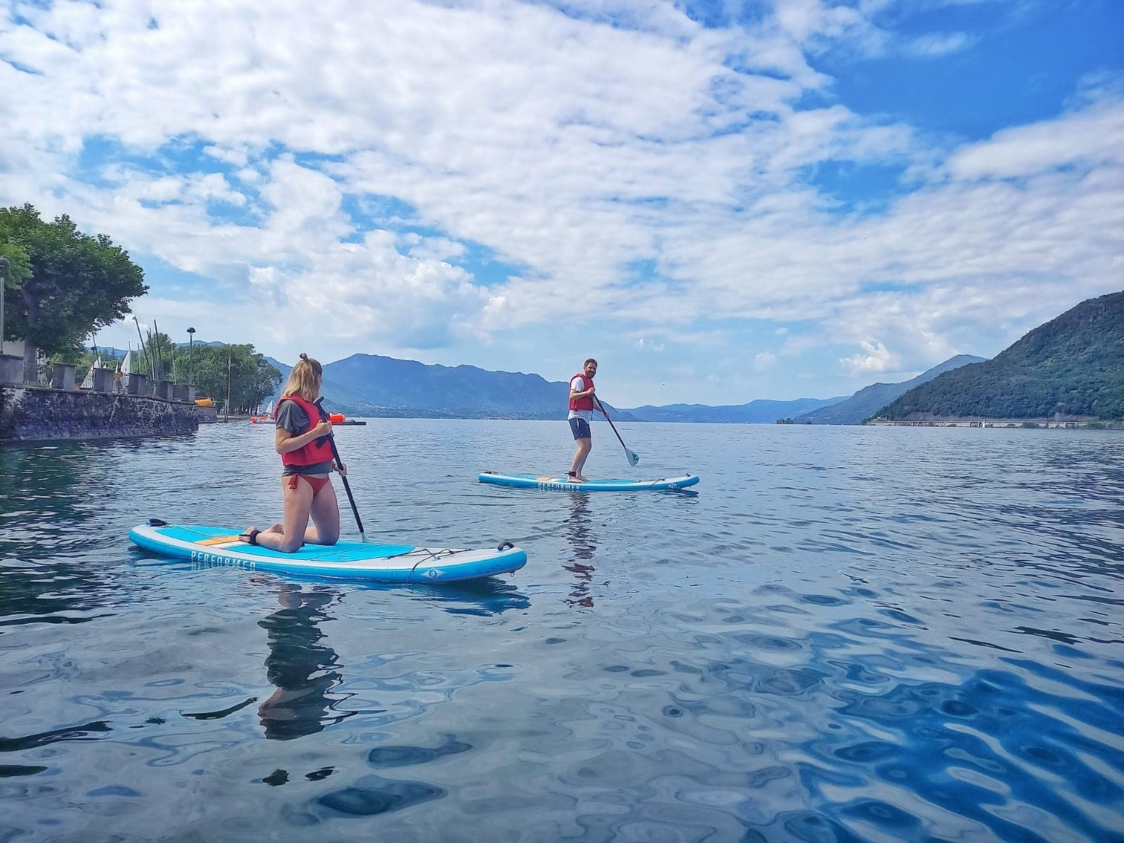 Stand-up paddleboarding on calm coastal bay with mountain vistas