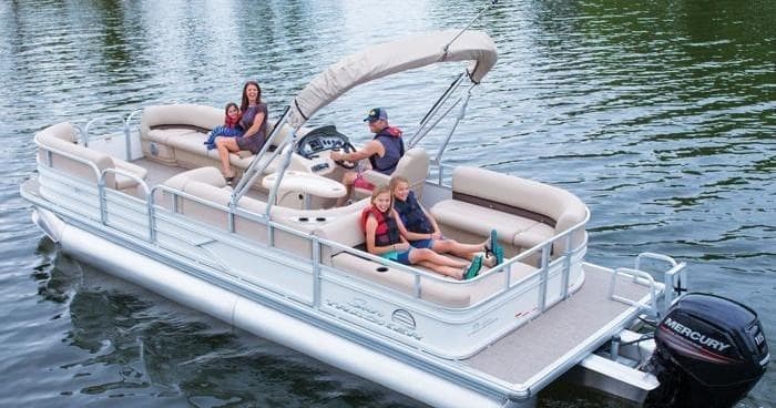 Friends relaxing on white pontoon boat in calm lake waters