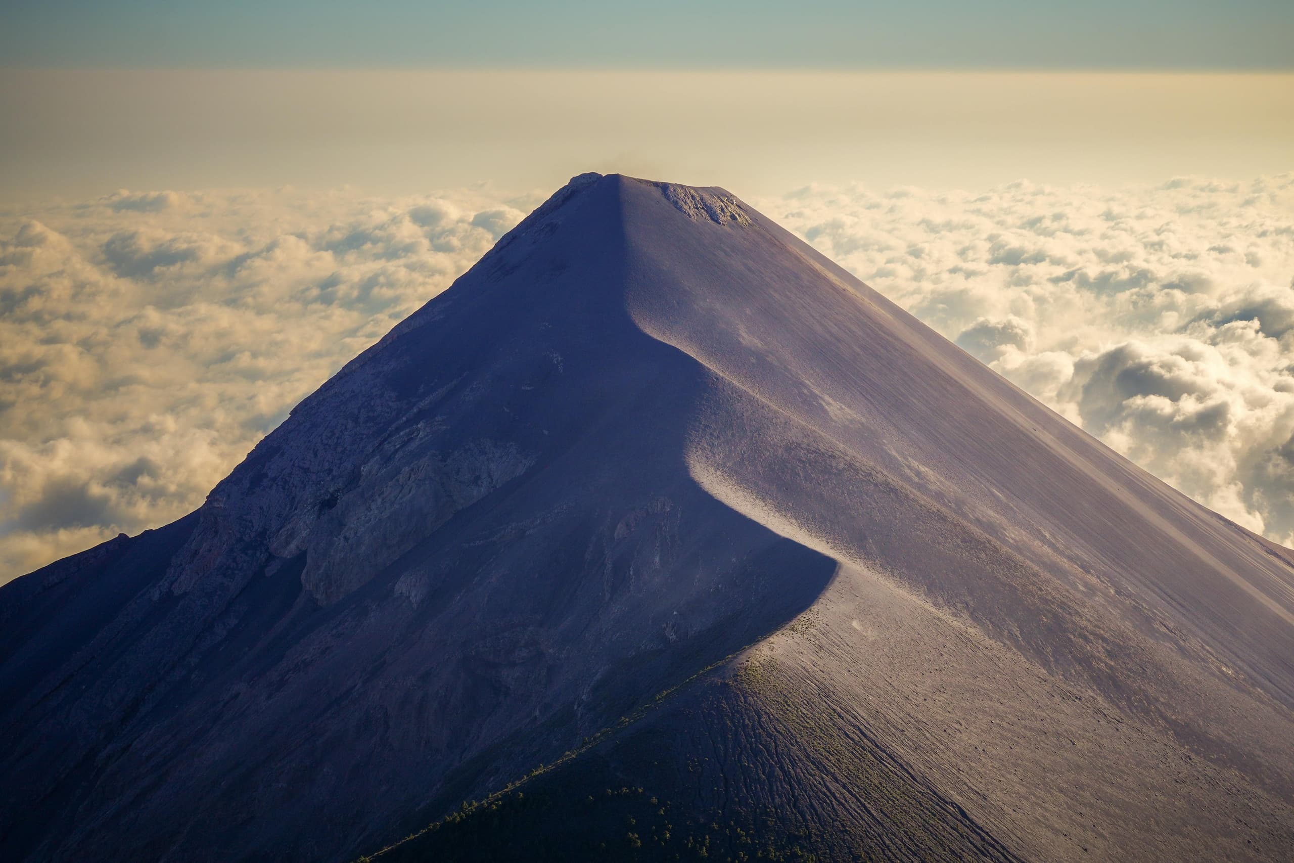 Volcanic summit above clouds showcasing high-altitude mountain trek