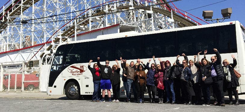 Group tour by bus outside Coney Island amusement park