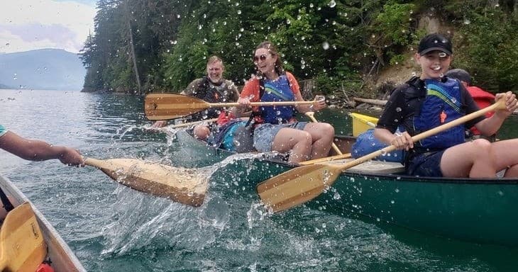 Canoe team paddling energetically with splashing water action