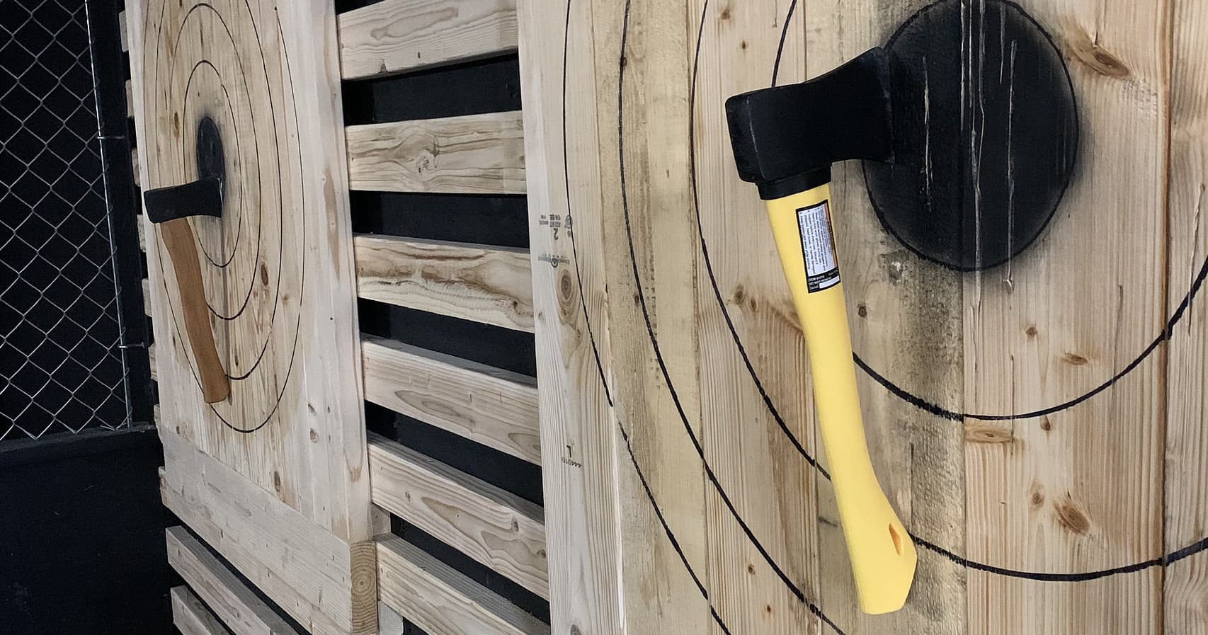 Indoor axe throwing lanes with axes stuck in wooden targets