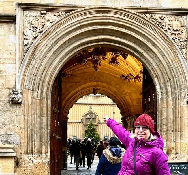 Tour group passing through ornate Oxford college archway