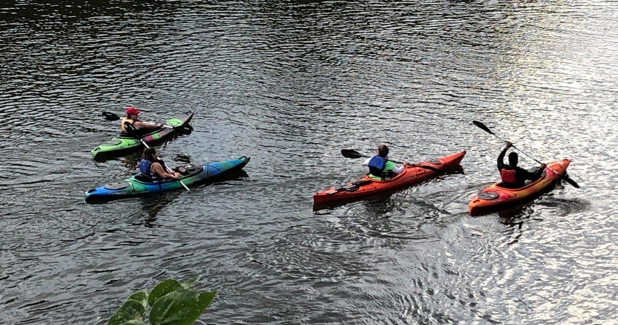 Group kayakers paddling on rippled river water during guided outing